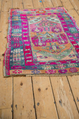 Vintage Kars rug's magenta wrapped side cord and dusty blue geometric ram's horn motifs.