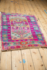 Vintage Kars rug lower corner showing magenta and dusty denim blue geometric patterns with abrashes.