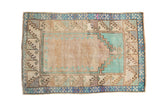 Vintage distressed Oushak rug with a stepped prayer design in pale turquoise, beige, and dusty blue.