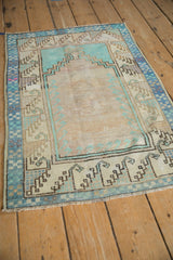 Corner view of the checkered dusty blue and ivory border on a vintage Oushak rug.