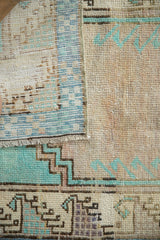 Close-up showing the hand-knotted foundation and worn pile of a vintage Oushak rug.