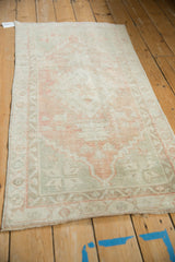 Distressed vintage Oushak runner texture with abrashed blush, ivory, and seafoam colors.