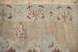 Evenly worn low pile showing the germinating tree border motif on a distressed Oushak rug.