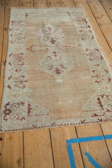 High-angle view of a distressed Oushak rug, highlighting its full pattern and soft, faded tones.