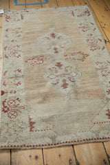 High perspective of a distressed Oushak rug, showing its soft texture and abrashed camel tones.