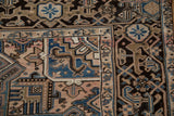Close-up of the vintage Mehrivan carpet's distressed geometric border in navy, beige, and rose.