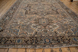 Distressed Persian Mehrivan field, beige, blue, and rose serrated buds, worn texture.