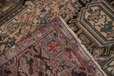 Folded edge of distressed Mehrivan carpet, showing fringe, binding, and worn motifs.