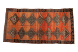Distressed hand-knotted vintage Kurd runner, rust-terracotta field, charcoal serrated diamond medallions, 4'11