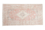 Distressed vintage Sparta rug, dusty rose, ivory, and oxidized silver floral medallion, 4'1