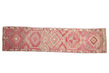 Distressed vintage Kurd runner with geometric medallions in varied magenta, pink, and ivory.
