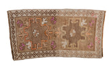 Distressed vintage Kars rug with a double medallion in brown, magenta, and faded orange tones.