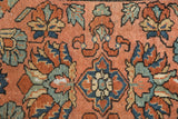 Close-up of vintage Lilihan rug: dusty blush field, blue and brick red floral vinery, visible foundation.