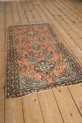 Vintage Lilihan rug side detail with delicate vinery, floral blossoms, and worn edge.