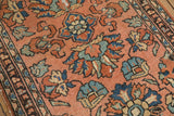 Vintage Lilihan rug detail: dusty blush field, blue, green, and red floral vinery, worn border.