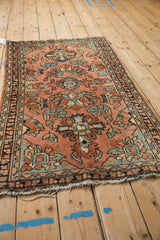 Vintage Lilihan rug's tattered fringe and floral motifs in dusty blush and ocean green.