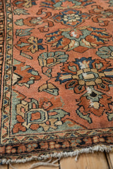 Vintage Lilihan rug close-up showing brick red field, detailed floral pattern, and tattered fringe.
