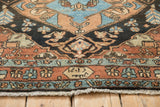 Close-up of the inscription cartouche and finely woven floral border on a vintage Heriz rug.