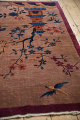 Pictorial Art Deco rug detail with a hut, cobalt blue blossoms, and burgundy border.