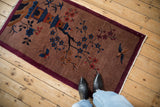 Vintage Chinese Art Deco rug with pictorial scene of a hut and tree, shown for scale.