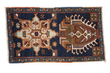 Vintage Persian Heriz rug mat, navy blue, with starburst and potted plant medallions.