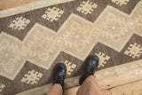 Ivory and brown zigzag geometric pattern on a distressed Oushak rug runner.