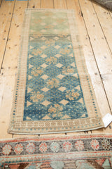 Distressed Oushak rug corner: sapphire blue and jade green abrashes, beige border.