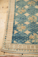 Distressed Oushak runner corner with sapphire blue field, floral motifs, sand border, and abrash.