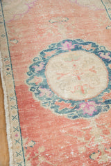 Textured cantaloupe field, dusty teal medallion, and ivory selvage on Distressed Oushak rug.