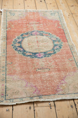 Faded floral motif inside the roundel medallion of a distressed Oushak rug.