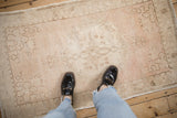 Distressed vintage Oushak rug shown underfoot to feature its scale and time-softened texture.
