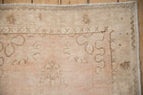 Low pile and even wear on a vintage distressed Oushak rug in dusty rose and pale coffee brown.