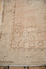 Corner spandrel showing the even wear and ribboned vine detail on a vintage Turkish Oushak rug.