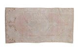 Vintage distressed Oushak rug runner with a faded scalloped medallion in pale pink, ivory, and coffee brown.