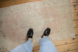 Looking down at the soft, worn texture of a vintage distressed Oushak rug runner underfoot.