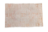 Distressed vintage Oushak rug with a faded hexagonal medallion in ivory, platinum, and pale rust tones.