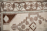 Vintage Oushak rug with distressed ivory, chocolate brown, and pale blue stepped geometric motifs.