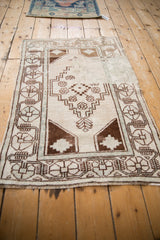 Distressed Oushak rug, ivory field with chocolate brown stepped medallion and geometric spandrels.