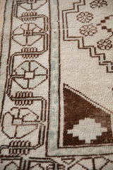Textured geometric patterns in brown and ivory on this vintage distressed Oushak rug.