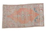 Vintage distressed Oushak rug with a faded cantaloupe melon field, central floral medallion, and stepped silver corners.