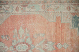Even wear and visible knot heads on the stepped corner of a distressed vintage Oushak rug.