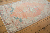 A distressed vintage Oushak rug runner with a cantaloupe melon field and stepped silver corners.