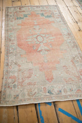 The decorative, time-softened wear on a vintage Oushak runner, viewed from a high angle.