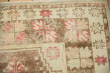 Distressed vintage Oushak rug fringe and coffee brown, dusty magenta starburst border.