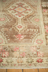 Vintage distressed Oushak rug showing coffee brown abrashes field and dusty magenta starburst floral border.