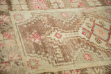 Textured abrashed vintage Oushak rug with dusty mauve and coffee brown serrated patterns.