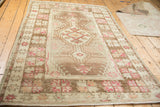 Oushak rug corner detail: coffee brown border with muted pink serrated motifs.