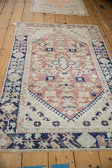 Dusty blush and ivory field with cobalt blue germinating plant motifs on Anatolian rug.