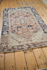 Corner of vintage Anatolian rug, with dusty blush, cobalt blue borders, hook-and-latch spandrels, and heavy abrashes.
