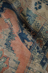 Abrashed melon, cobalt, and sand tones on a distressed vintage Oushak rug.